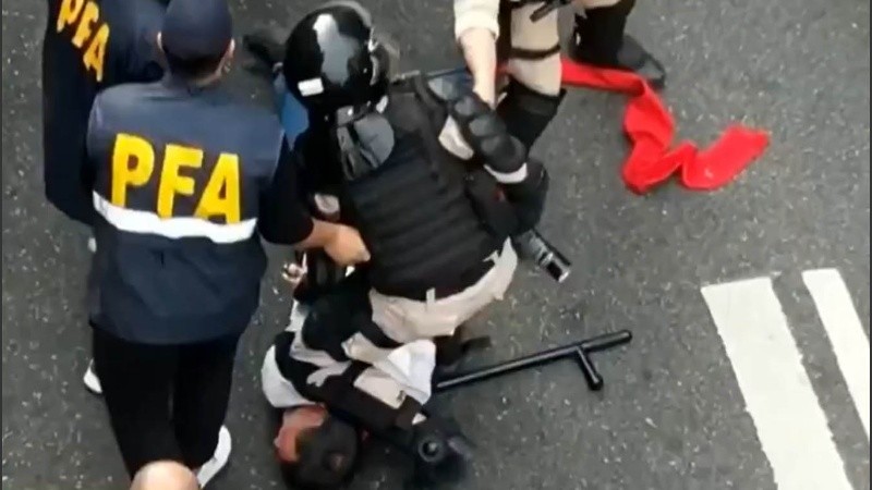 Captura 2: un agente retiene por la fuerza contra el piso al cura.