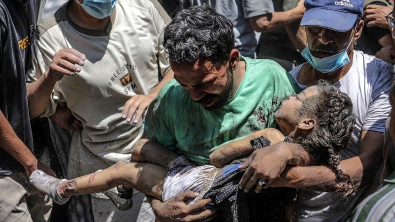 Una niña rescatada ayer de los escombros de una casa destruida tras un ataque aéreo israelí en la ciudad de Gaza, Franja de Gaza.